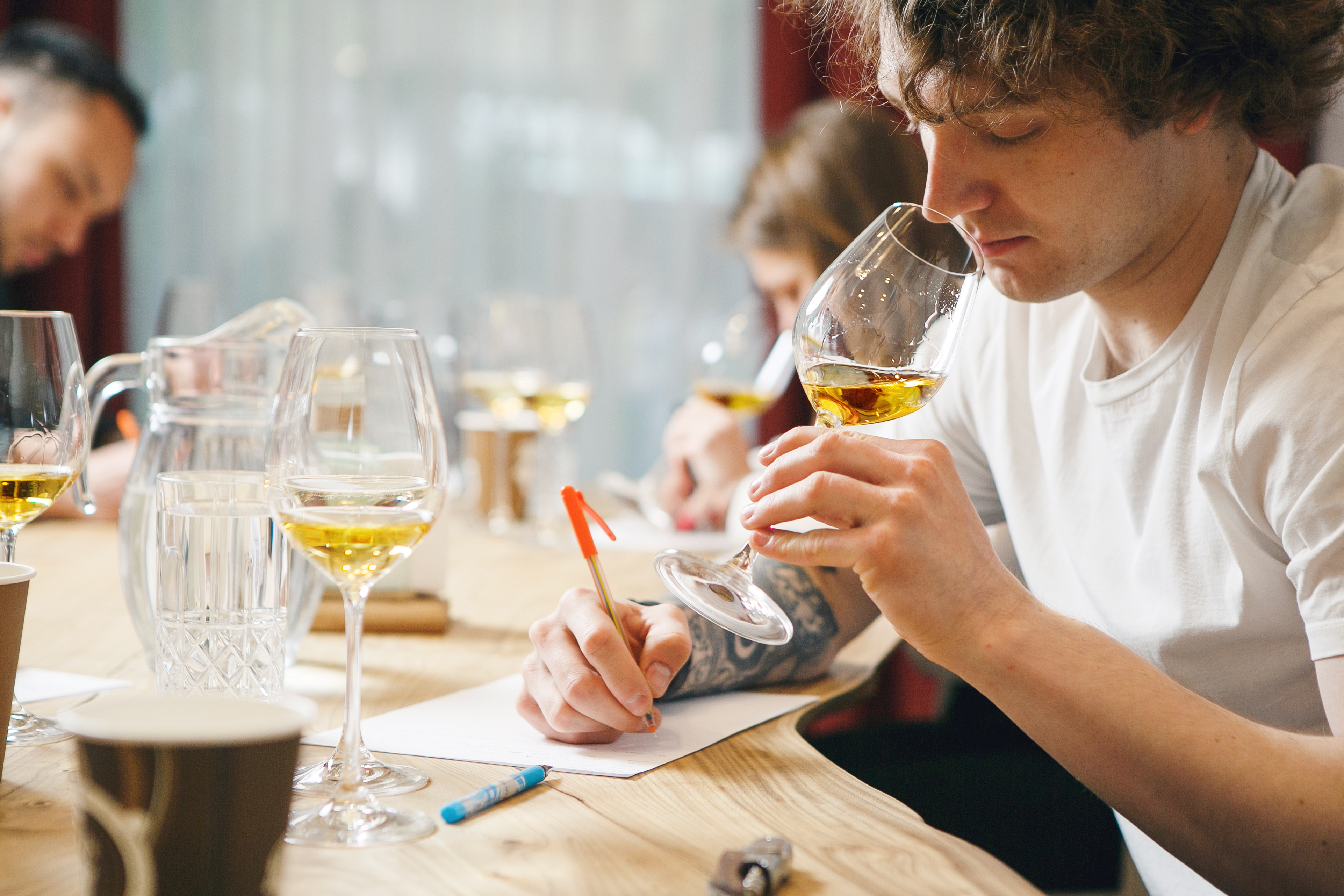 A wine professional studying at a table with wine glasses